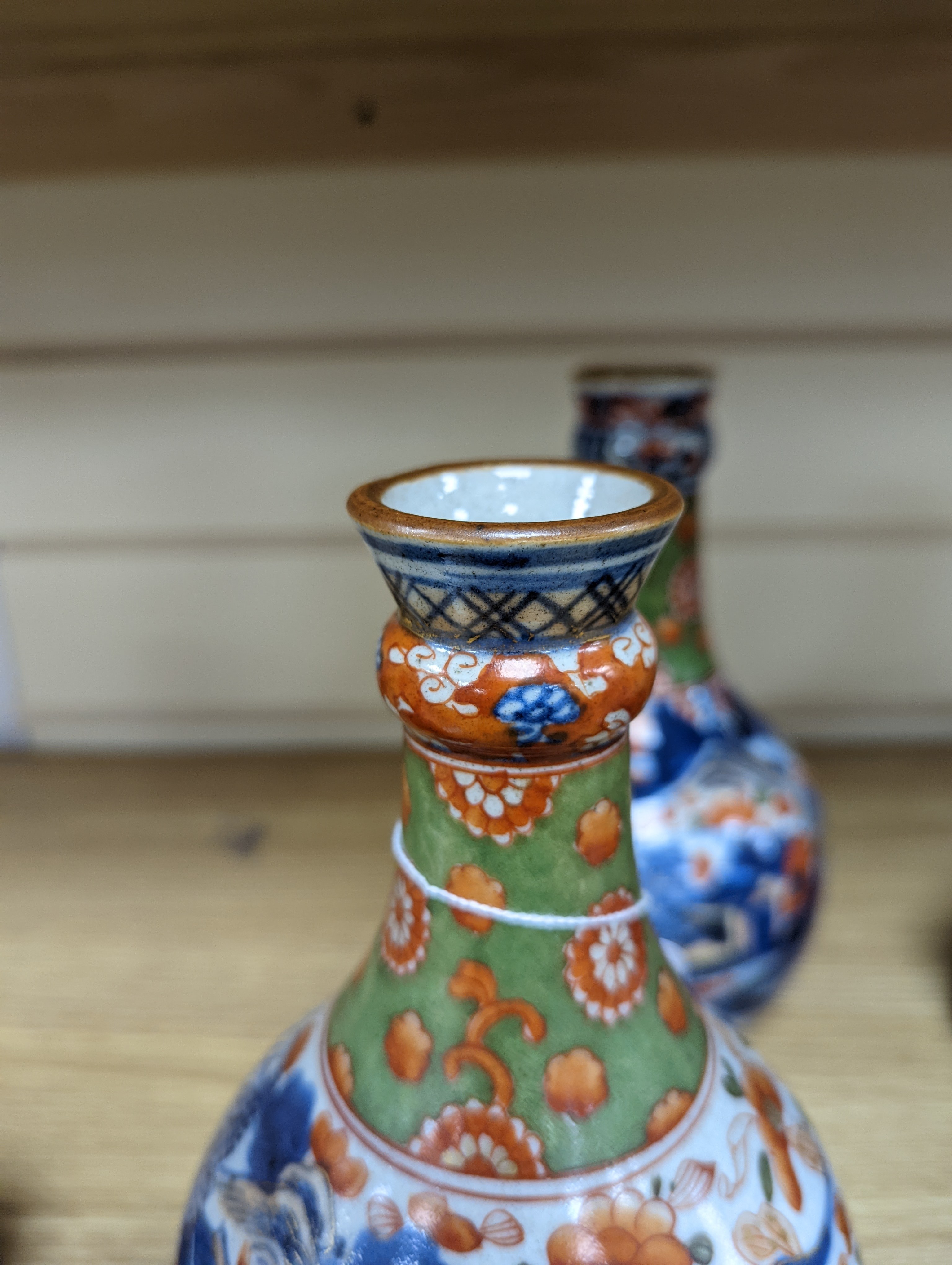 A pair of 18th century Chinese clobbered blue and white bottle vases 23cm
